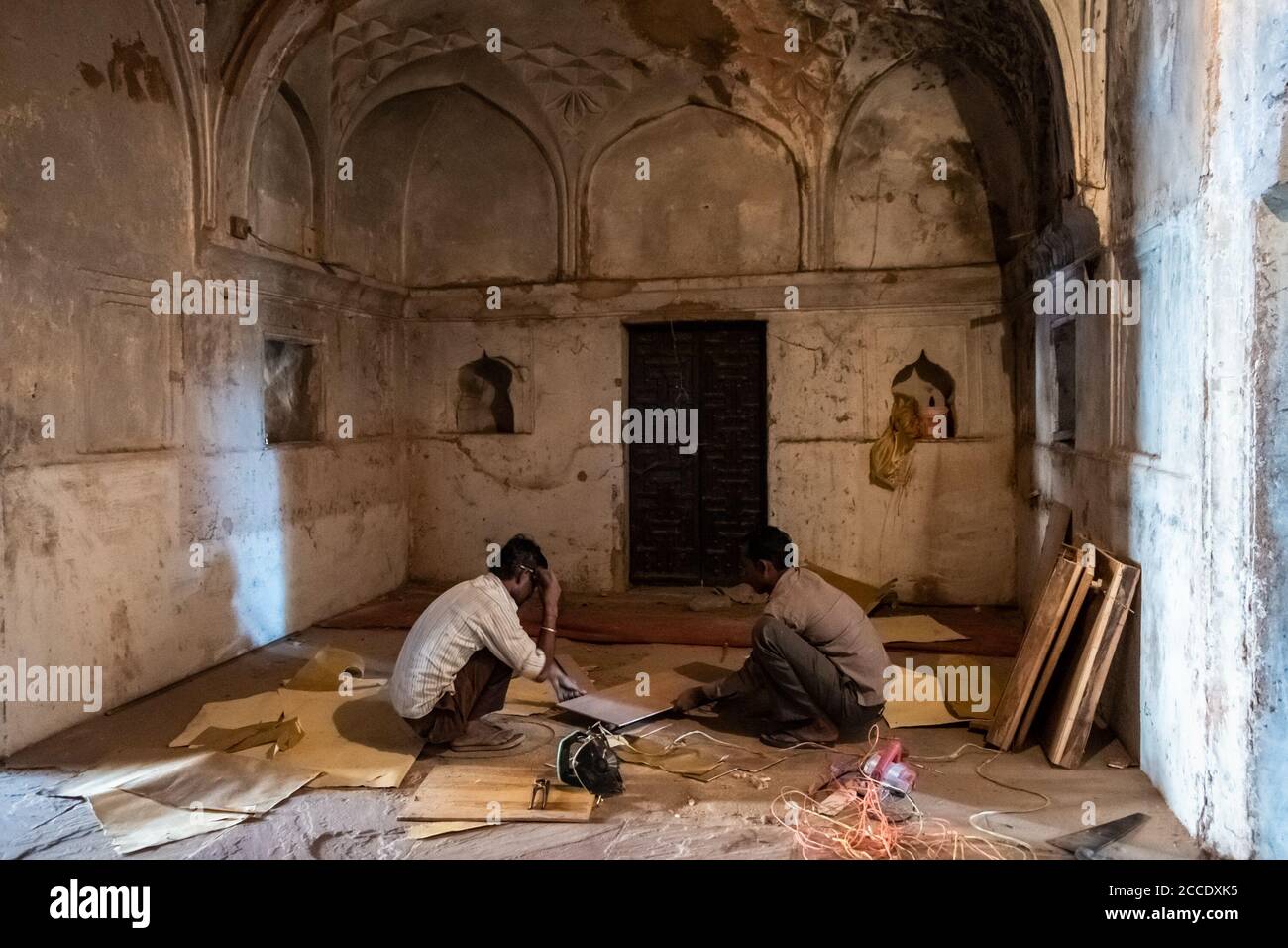 Orchha, Madhya Pradesh, India - March 2019: Carpenters doing restoration work inside a dark hall of the Jehangir Mahal palace in the Orchha Fort. Stock Photo