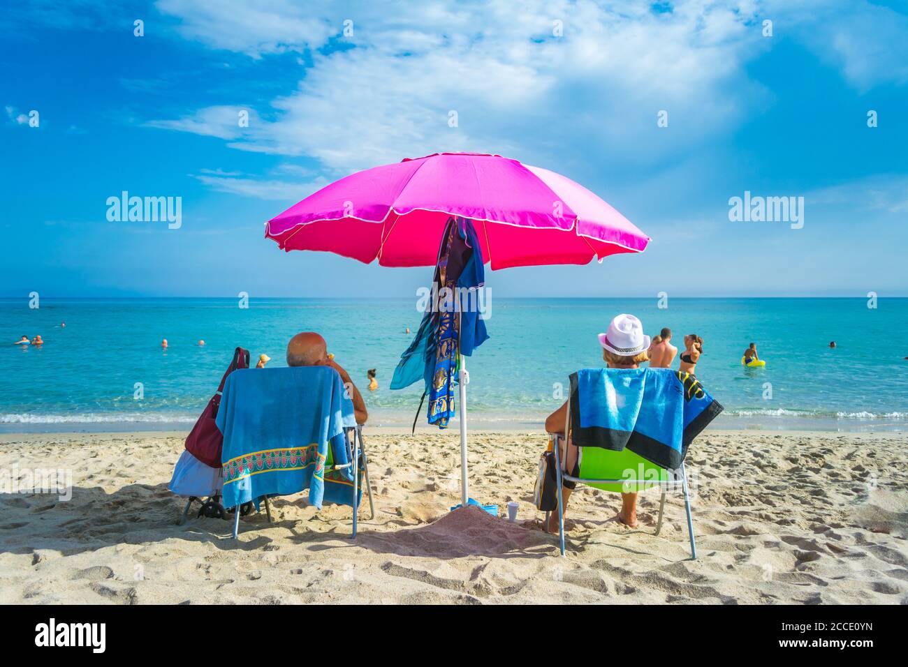 Pink beach umbrella near the sea Stock Photo