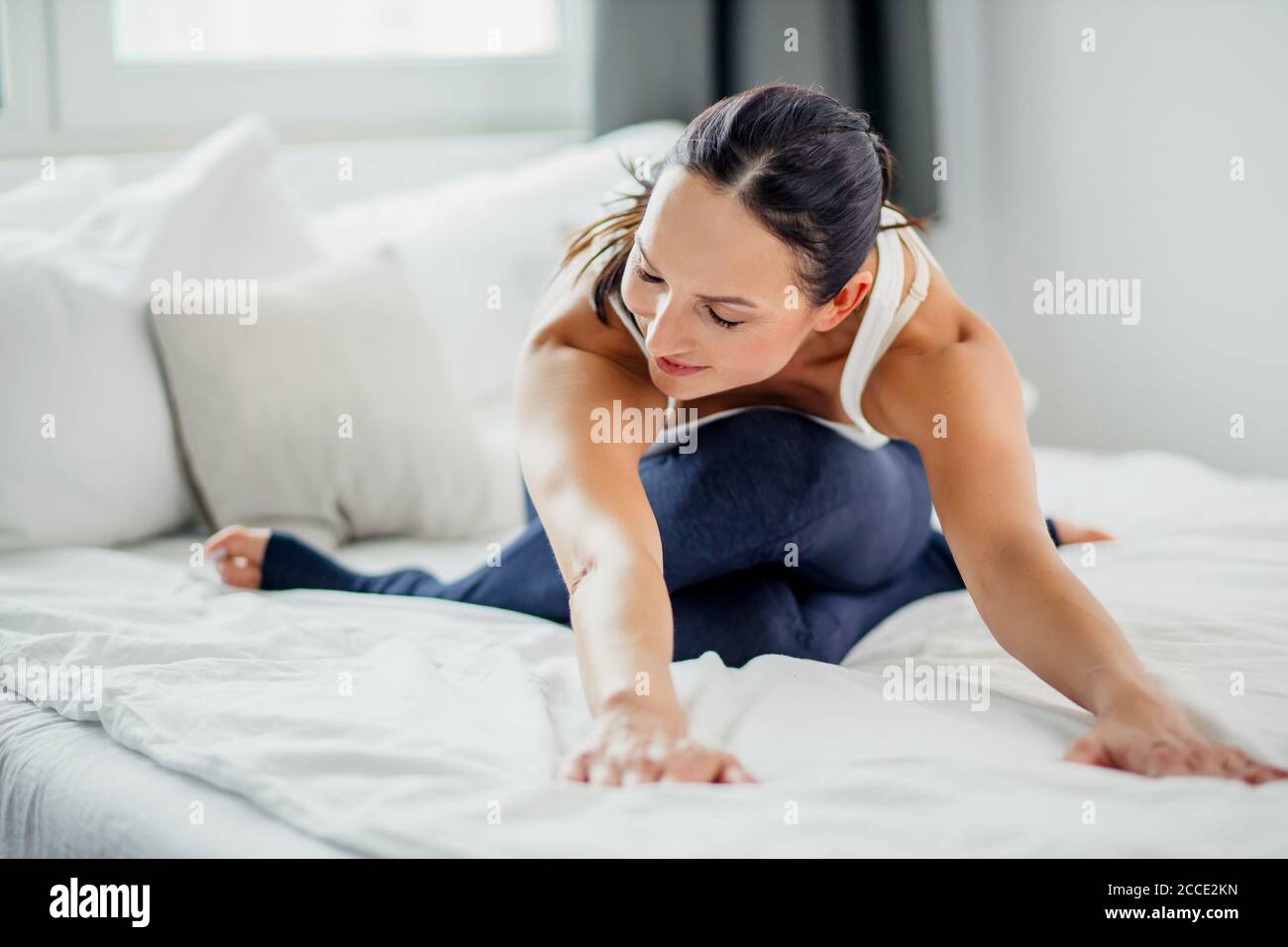 sport and healthy lifestyle concept. young flexible woman do exercises at home, every morning begins from stretching and fitness, wellbeing Stock Photo