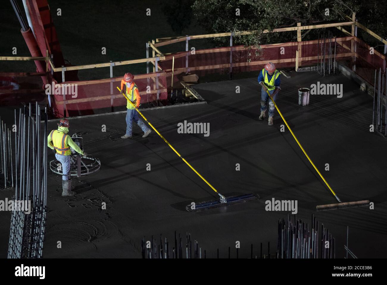 Austin, TX USA July 25, 2020 Concrete workers use longhandled screeds