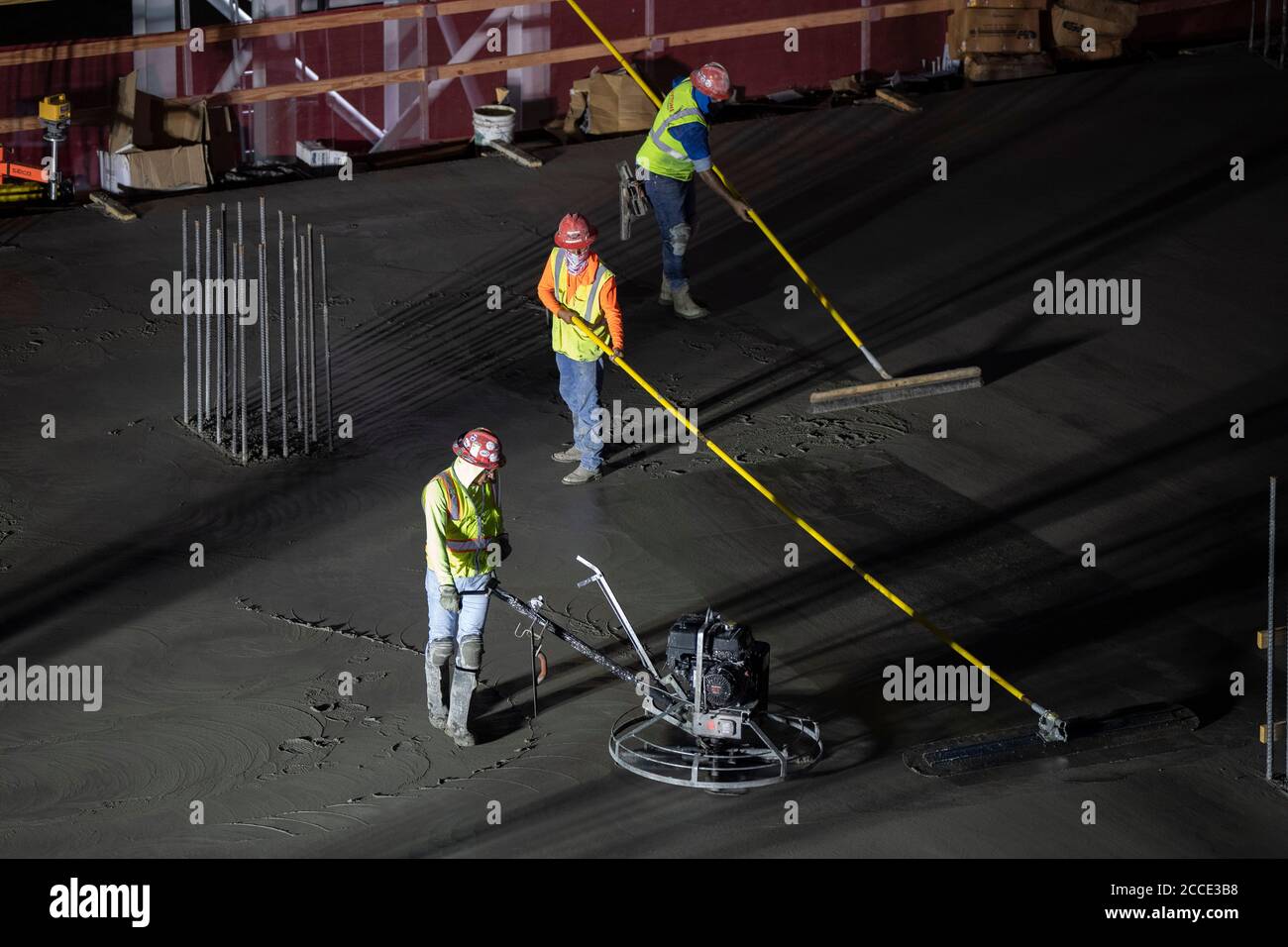 Austin, TX USA July 25, 2020 Concrete workers use longhandled screeds