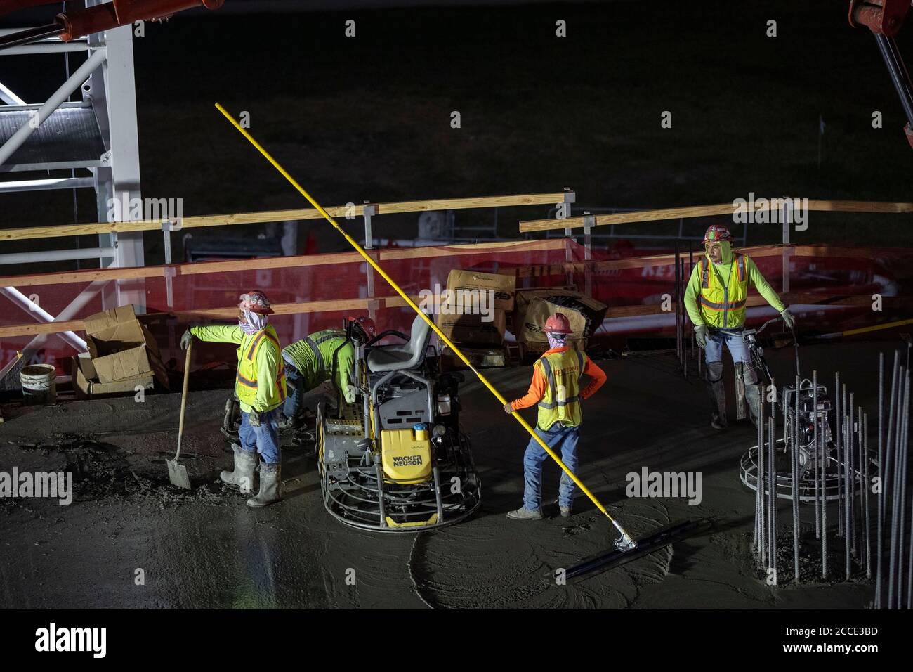 Austin, TX USA July 25, 2020: Concrete crews work on the parking garage of a 53-story building during a night-time pour in the Rainey Street District of downtown Austin, TX. Huge construction projects continue unabated in Texas despite the nationwide COVID-19 pandemic and the state stricken with over a half million cases and 10,000-plus deaths. Stock Photo