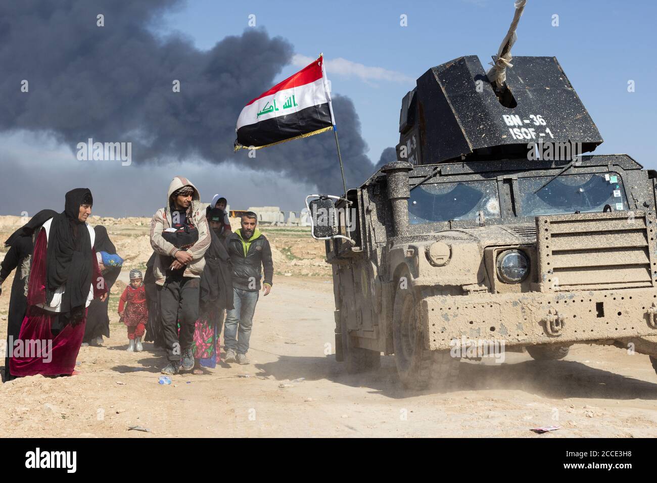 Mosul, Iraq. 7th Mar 2017 Civilians flee their homes near Tall ar Rayyan neighborhood as a Iraqi Special Forces Humvee passes by in West Mosul. Credit: Young G. Kim Stock Photo