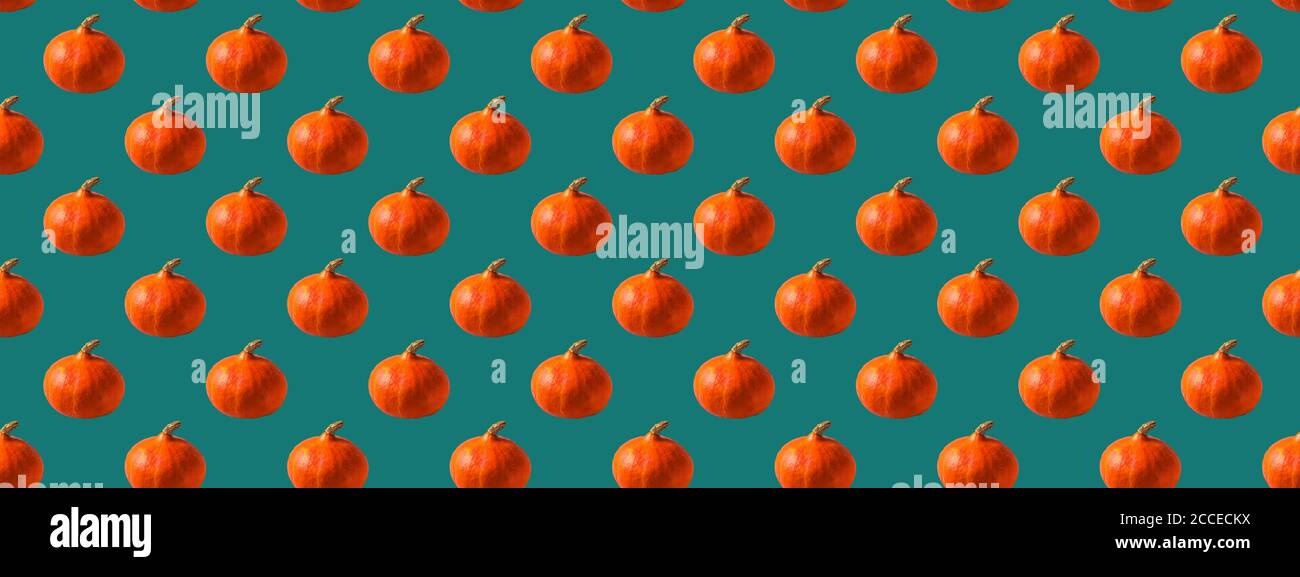 Seamless pattern made with an orange pumpkin on a blue background. Stock Photo