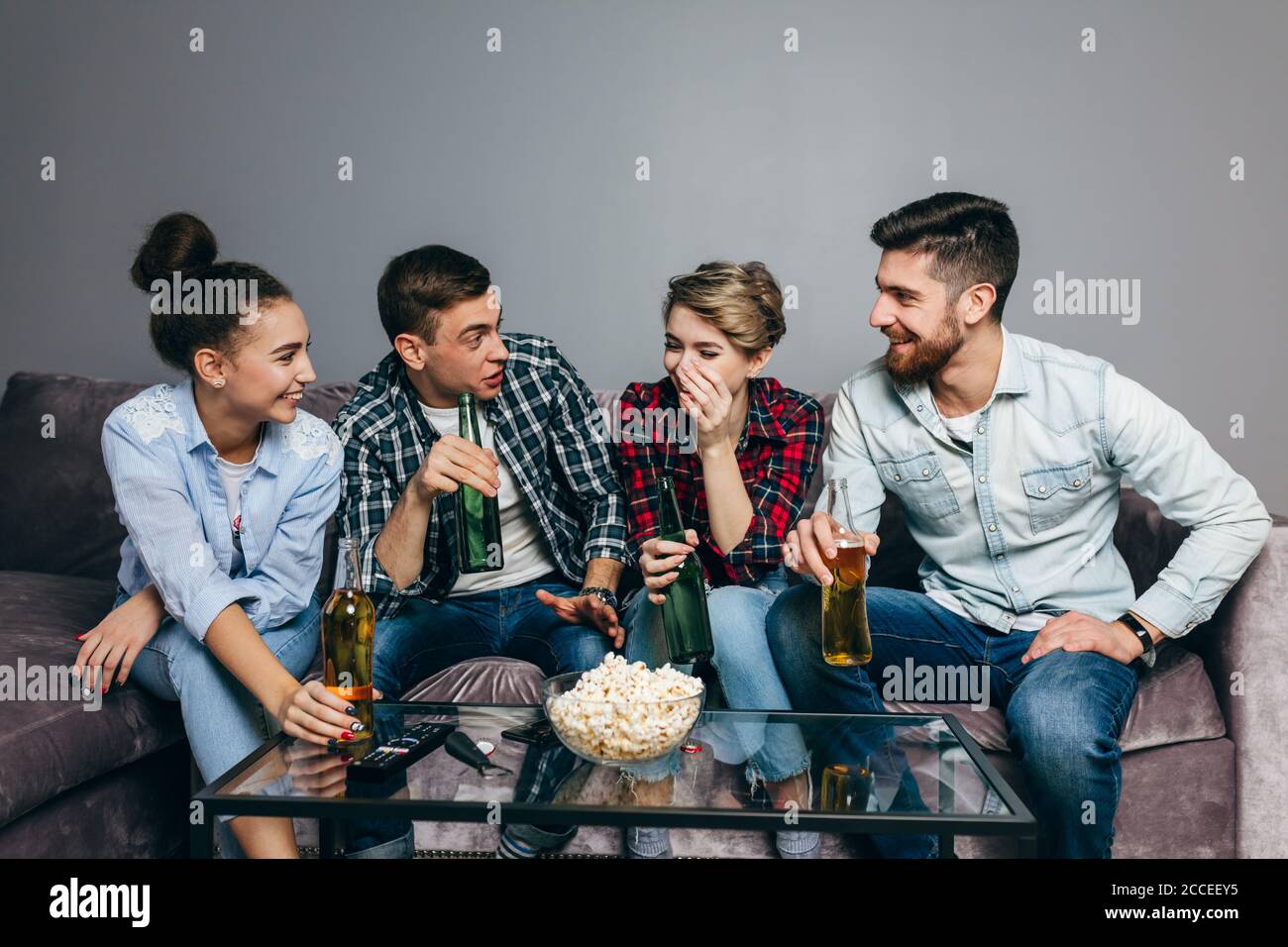 young gorgeous people are telling jokes while sitting on the sofa indoors. close up shot Stock Photo