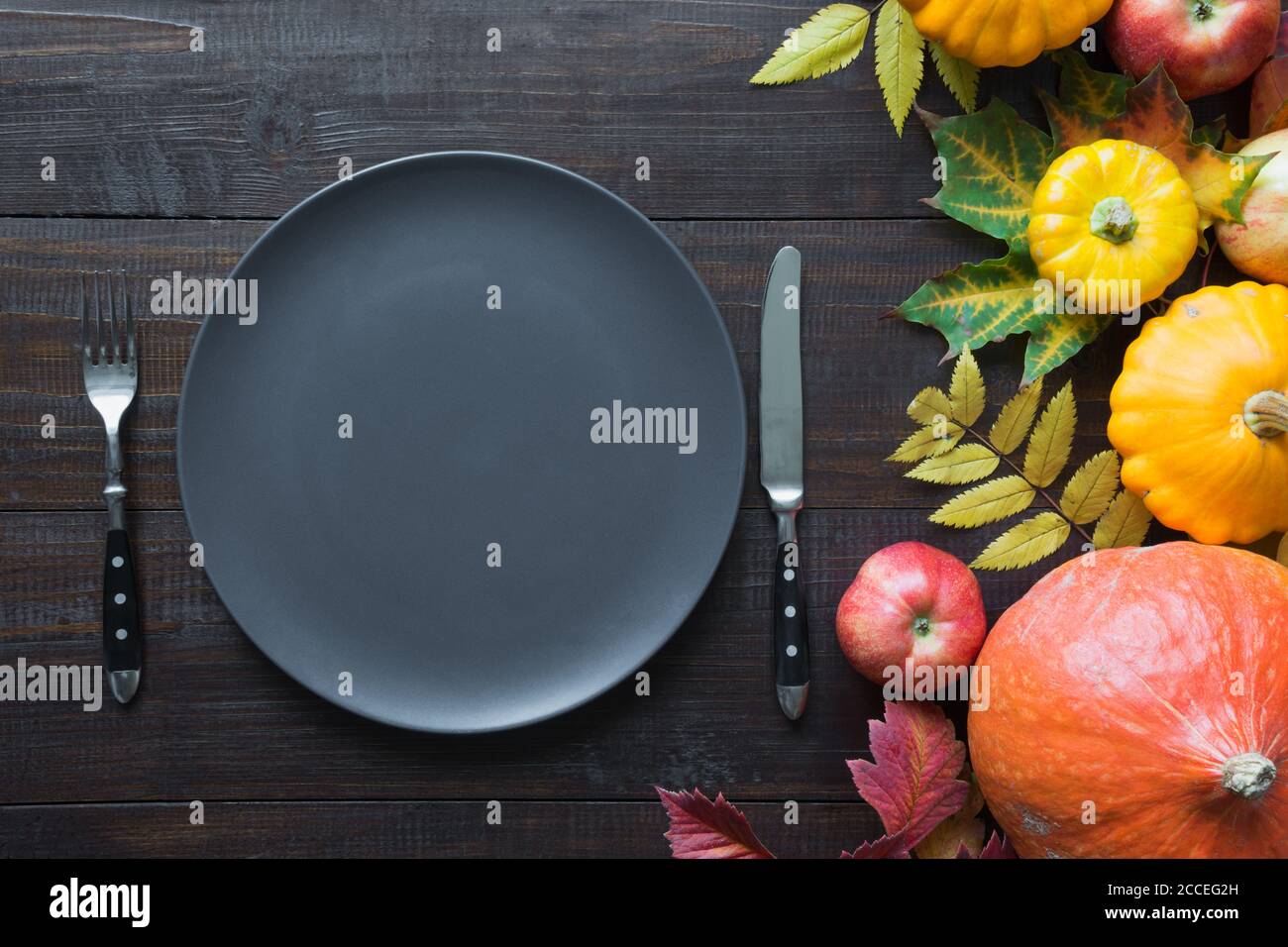 Fall table place setting with autumn harvest, pumpkins, aplles. Thanksgiving Day. Stock Photo