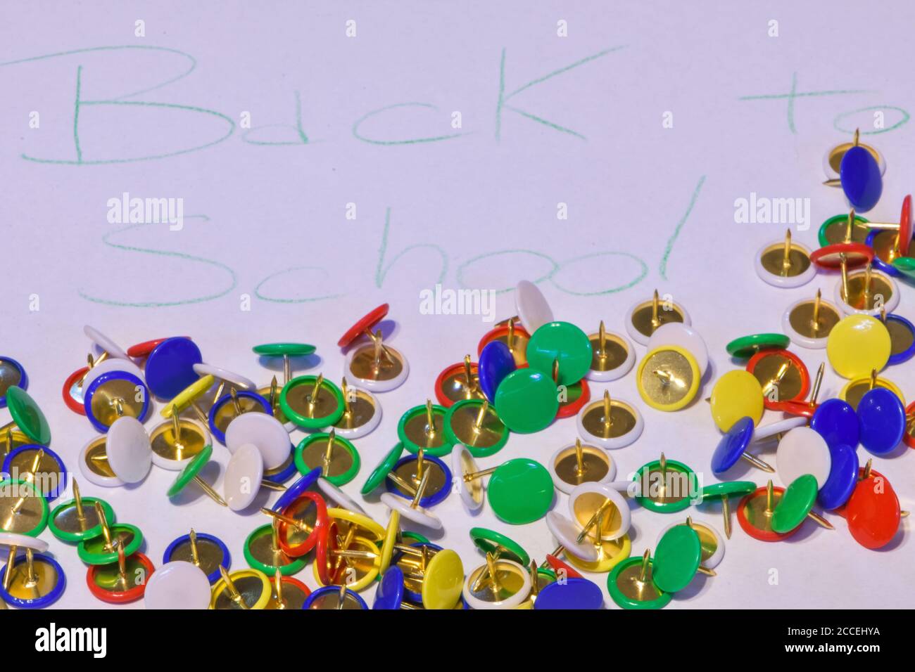 thumbtacks scattered on a white paper with the words "back to school