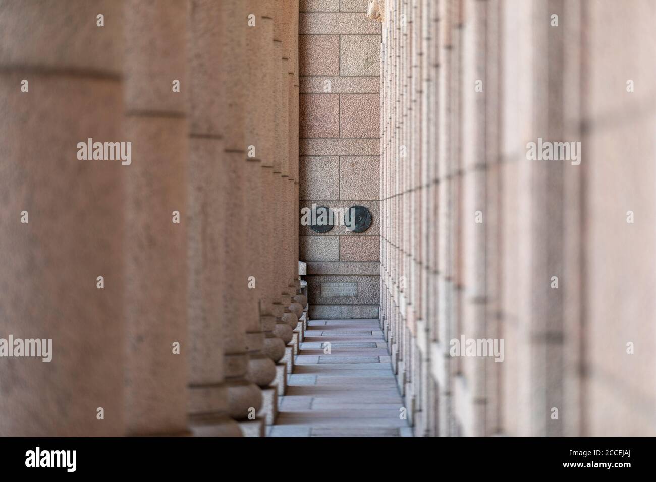 Red granite colonnade is a trade mark feature of Finnish parliament building. On back wall is the name and signature of architect: J.S.Siren. Stock Photo