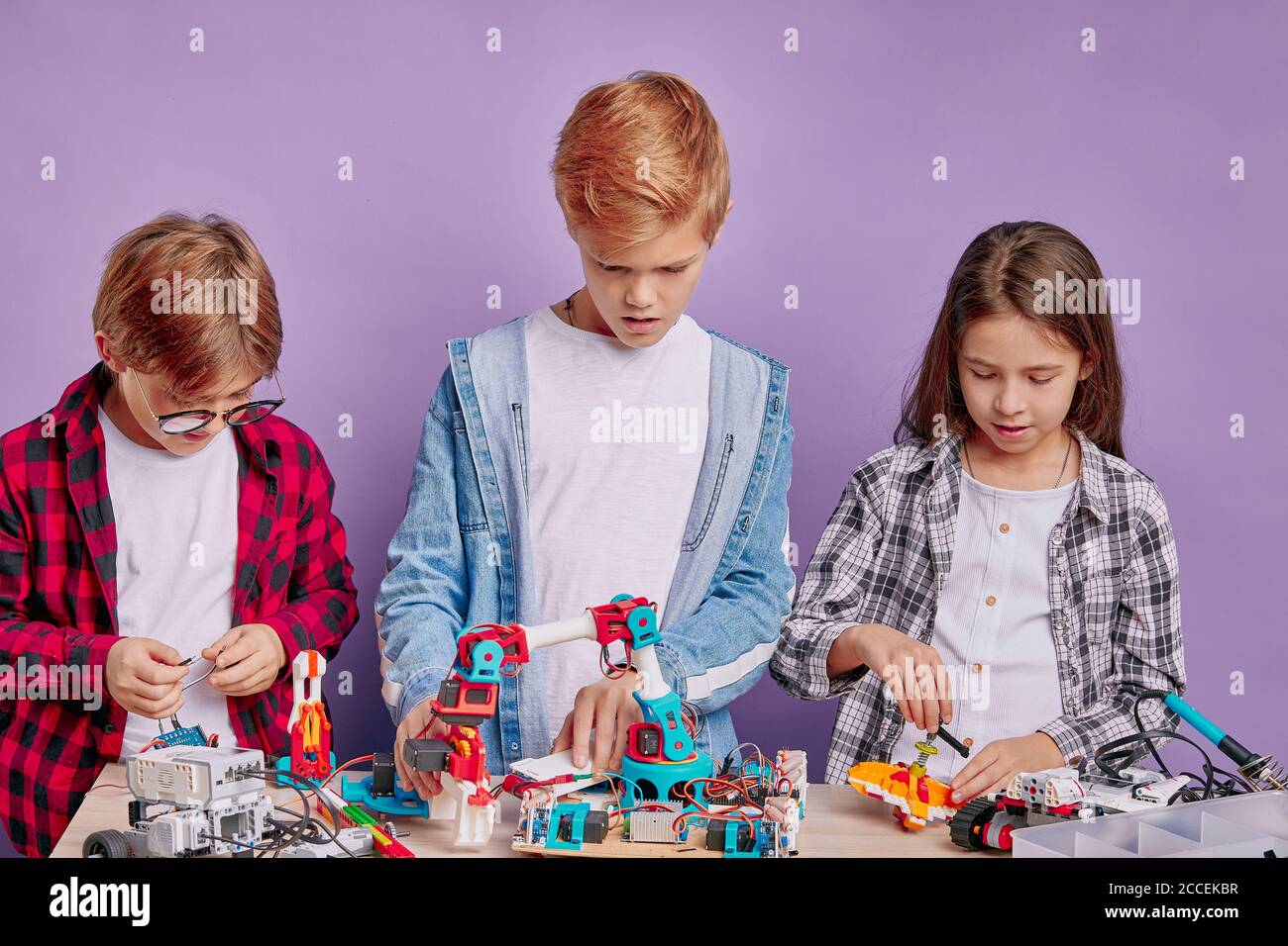robotics activity of three caucasian children assembling toys, future ...