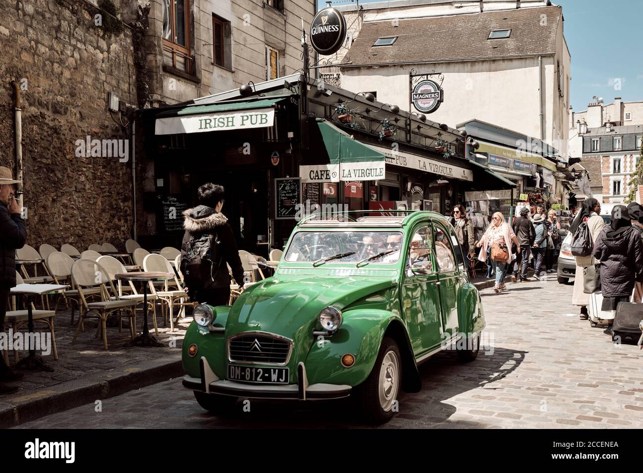 Europe, France, Paris, Montmartre, Sacre Coeur, Old car driving tourists through streets of montmartre, Citroen 2cv, green car Stock Photo