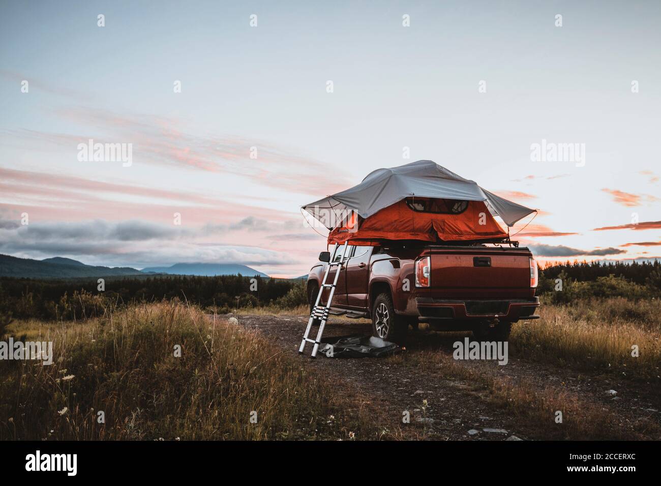 Roof top tent on pick up truck in remote campsite in woods of maine