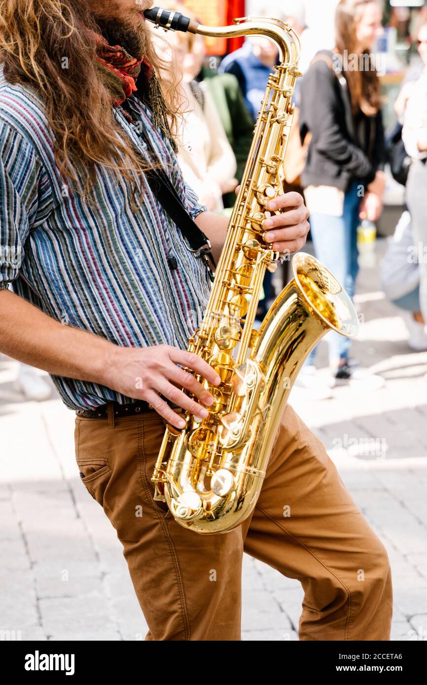Vertical photo of the hands of a young man with long hair playing