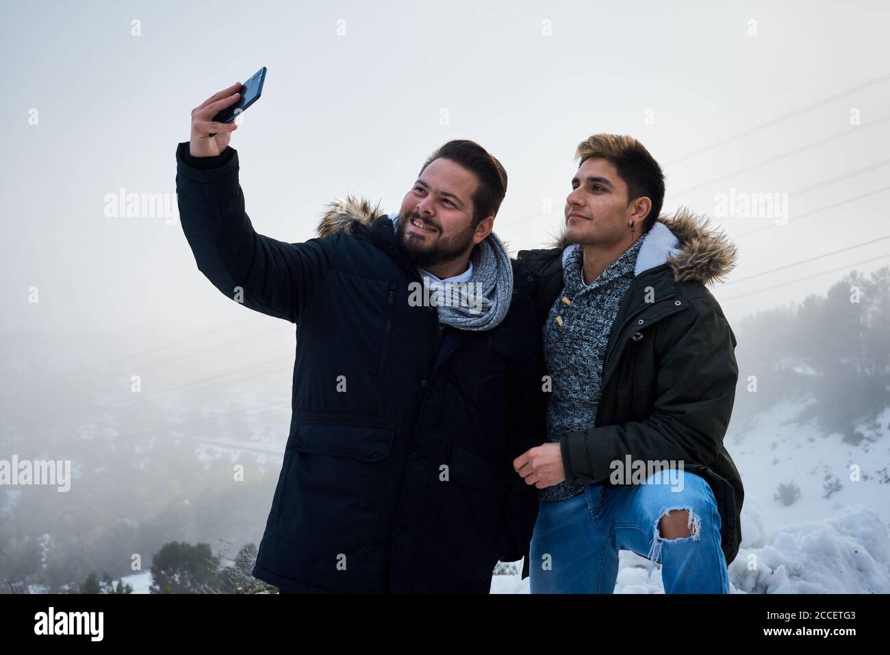 Two guys pose and take a picture with their phone surrounded by snow Stock  Photo - Alamy