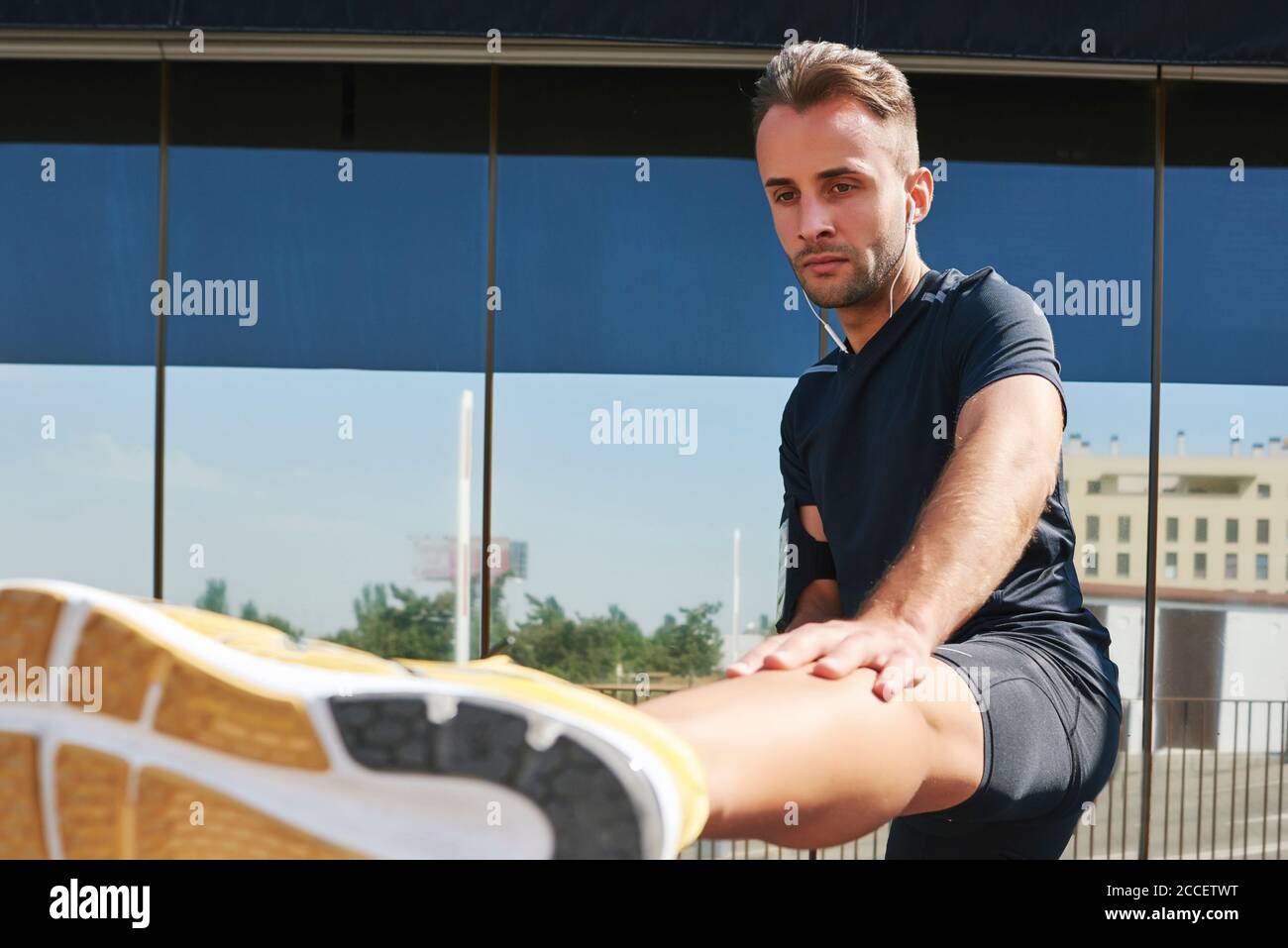 Sportsman stretching muscles after exercise Stock Photo - Alamy
