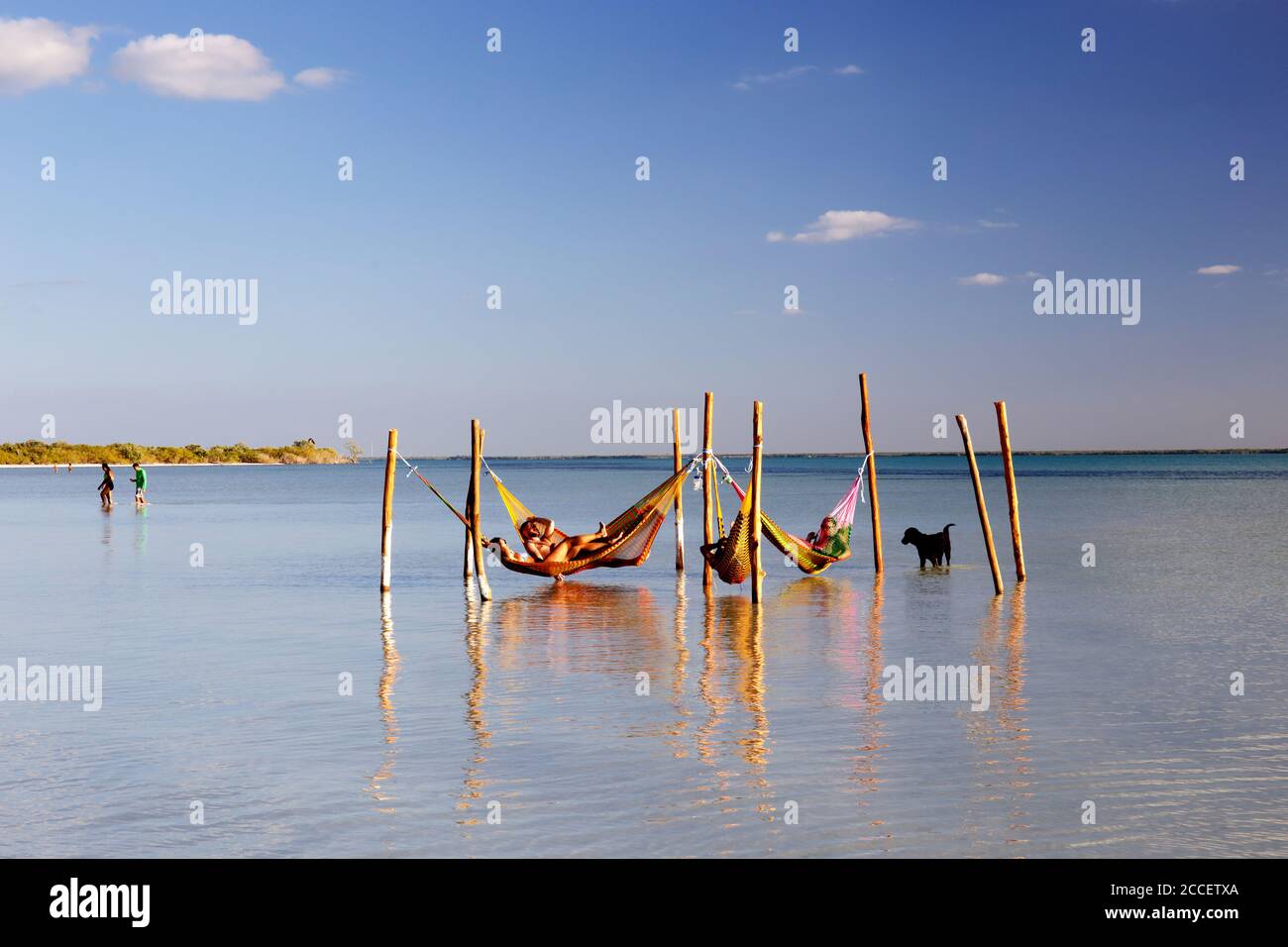 Tourists sunbathing on a beach of Holbox next to some hammocks. Holbox Island, Cancun, Yucatan