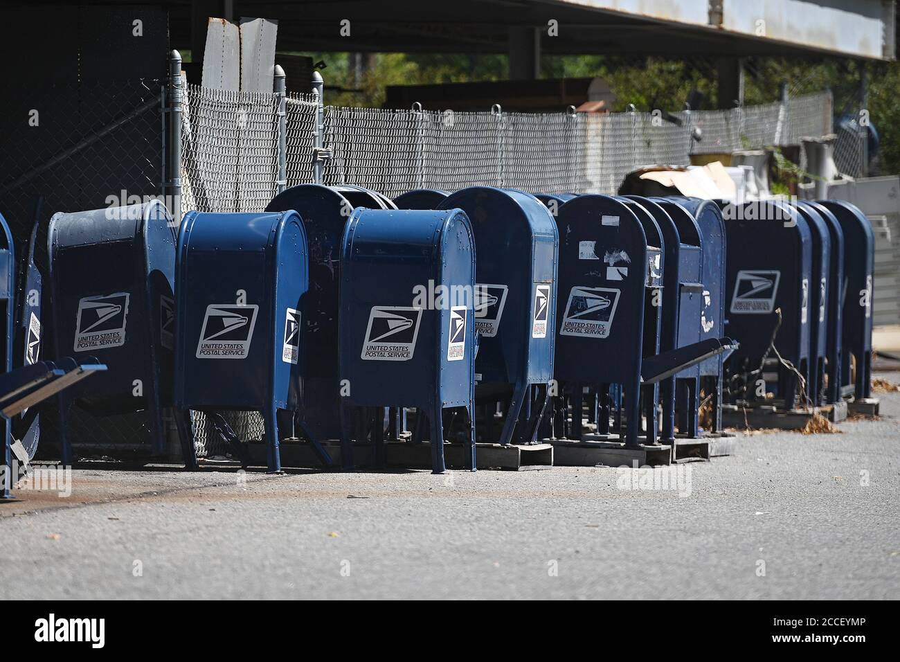 New York City, USA. 18th Aug, 2020. Seen through a perimeter fence, blue U.S. Postal Service collection boxes sit gathered in the parking lot behind a Post Office in the New York City borough of the Bronx, NY, August 18, 2020. The USPS has announced that it will stop removing mailboxes for ninety days for the expected surge of mail-in ballots rather than people going to polls due to the COVID-19 pandemic, but explained that removal was due to the lack of use. (Anthony Behar/Sipa USA) Credit: Sipa USA/Alamy Live News Stock Photo