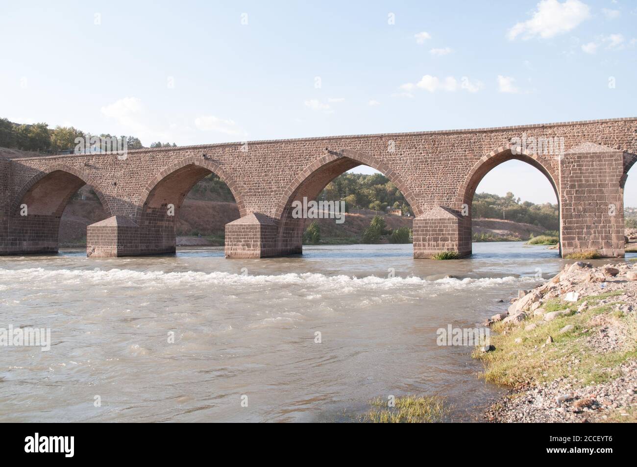 An old 11th century Seljuk stone bridge across the Tigris River, on the edge of the city of Diyabakir, in eastern Anatolia, southeastern Turkey. Stock Photo