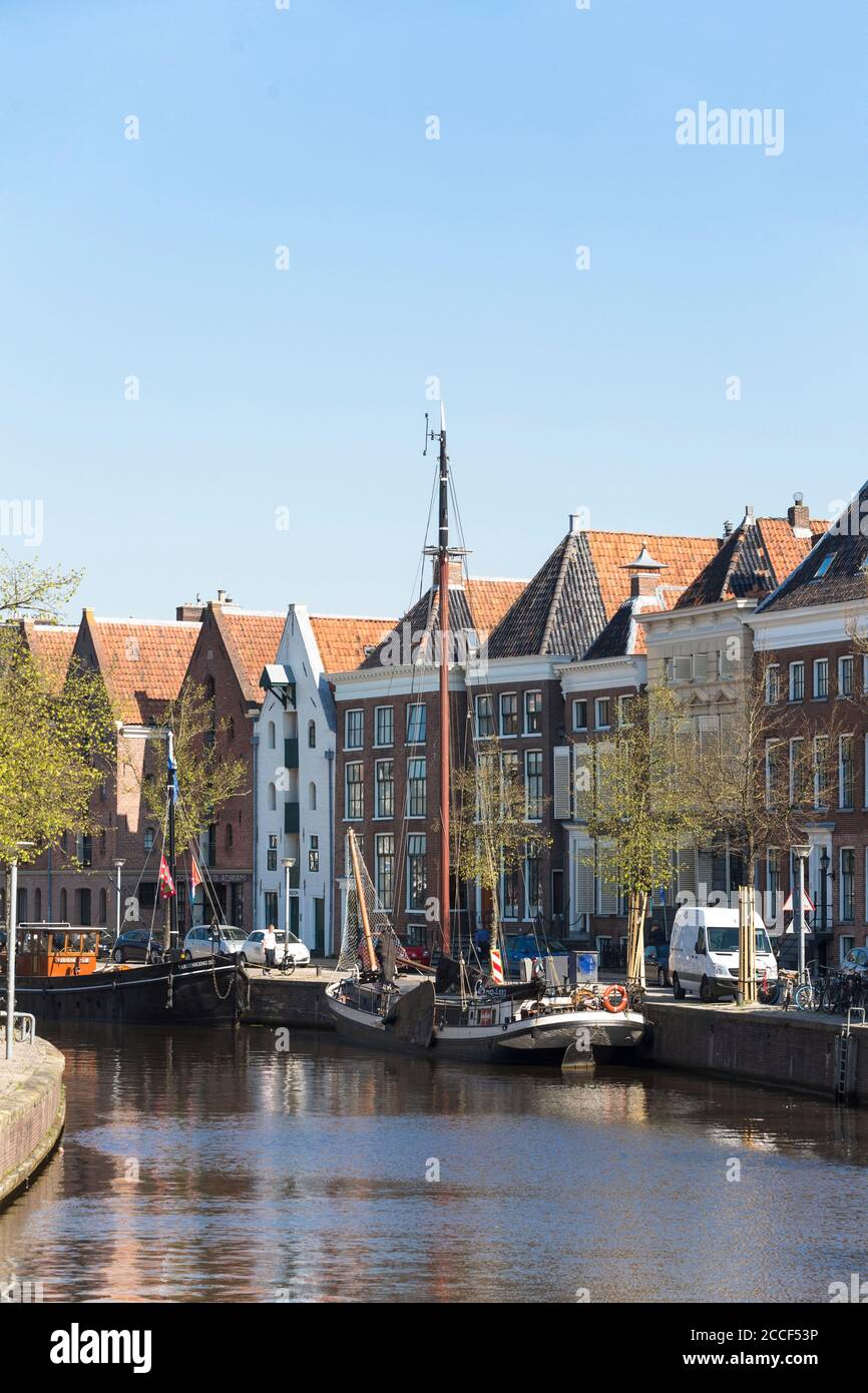 View of the canals with the old traditional sailing ships and the historic houses in the city center of Groningen, Netherlands Stock Photo