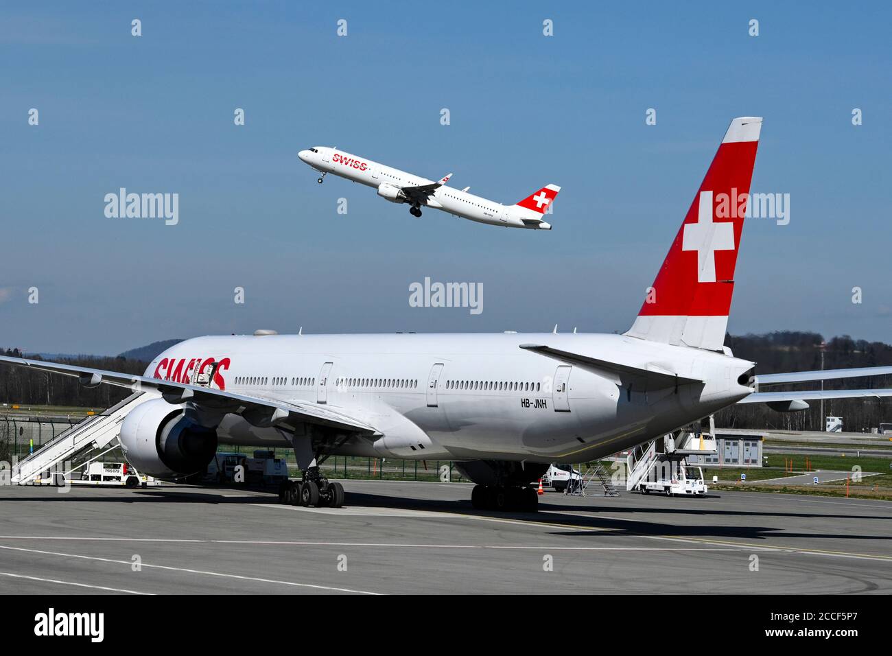 Airplane Swiss Airbus A321-200, HB-IOO taking off, vo. Swiss Boeing 777-300, HB-JNH, on the ground, Zurich Kloten, Switzerland Stock Photo