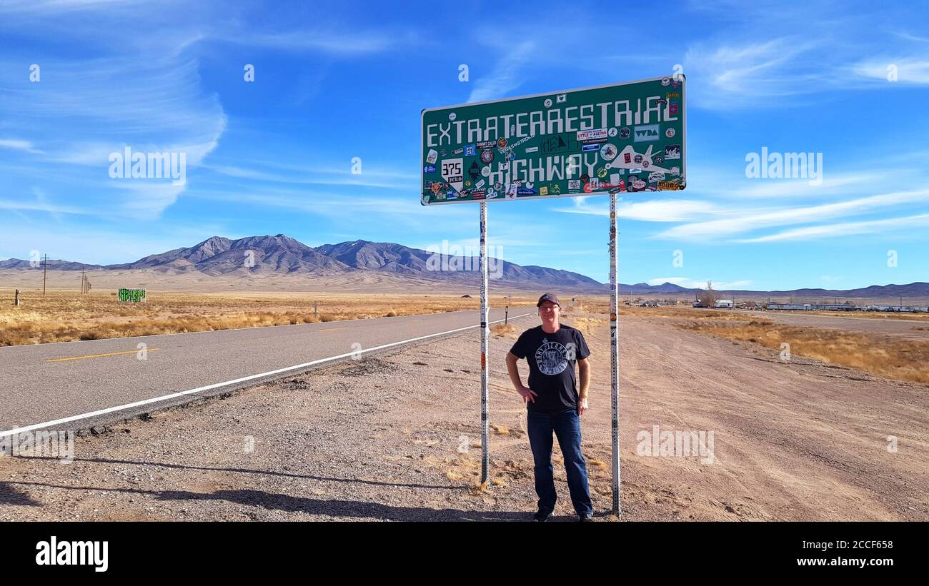 Tourist standing in front of the Extraterrestrial Highway sign, Nevada USA Stock Photo