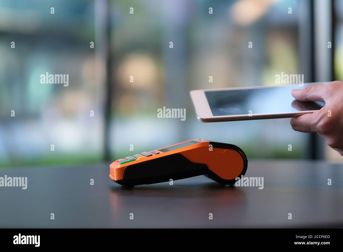 close up people using digital tablet to pay over pos terminal on table. blur background Stock Photo