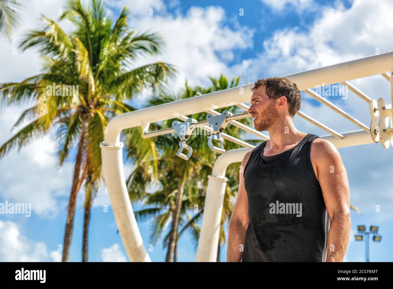 Outdoor calisthenics gym park male athlete working out on monkey bars outside in summer. Man workout Stock Photo