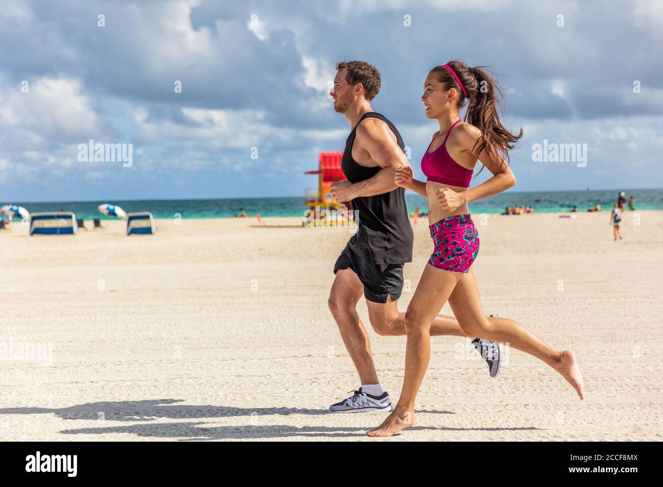 Running people jogging exercising on South Beach, Miami, Florida. Man and  woman training partner runners working out together. Lifestyle active  people Stock Photo - Alamy