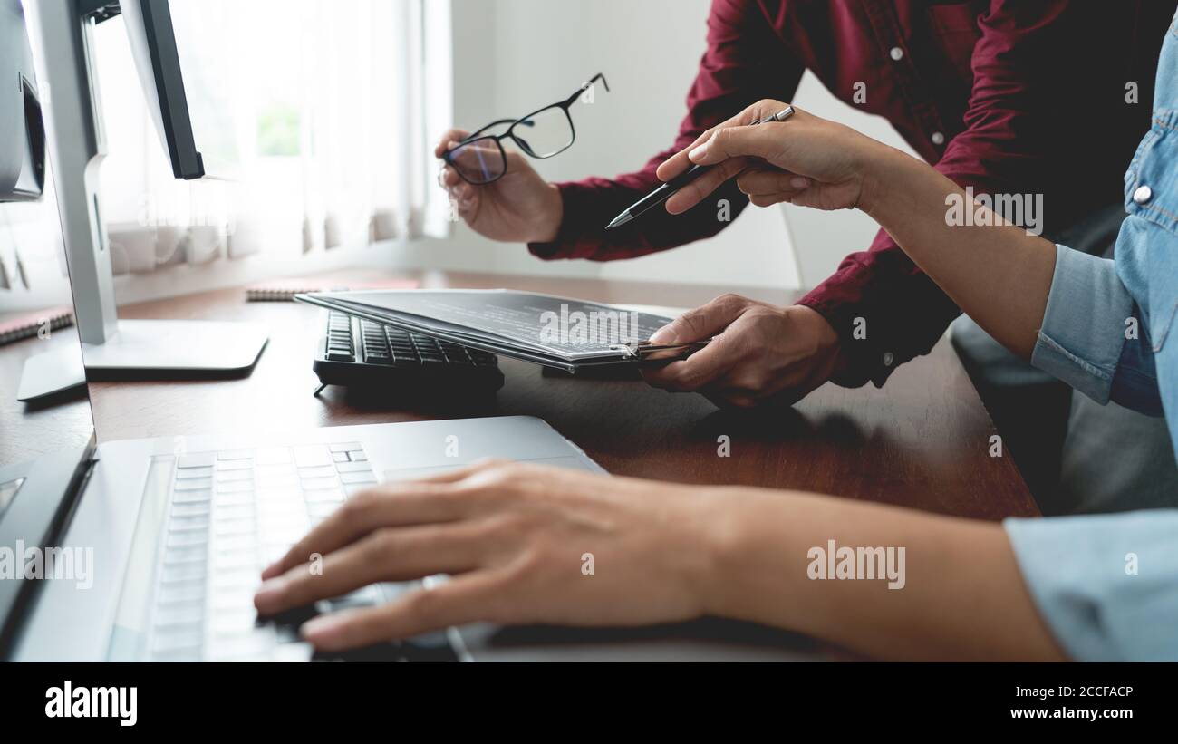 Team of Programmer working to find solution to problem and coding technologies in a software developing company office Stock Photo