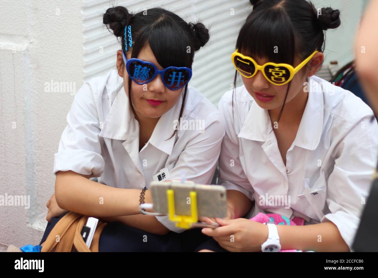 Two teenage girls taking selfies in Takeshita dori, Harajuku Stock Photo