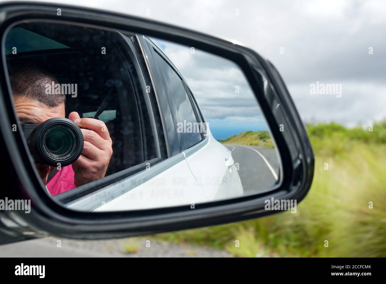Road trip taking a photo reflected in side view mirror Stock Photo