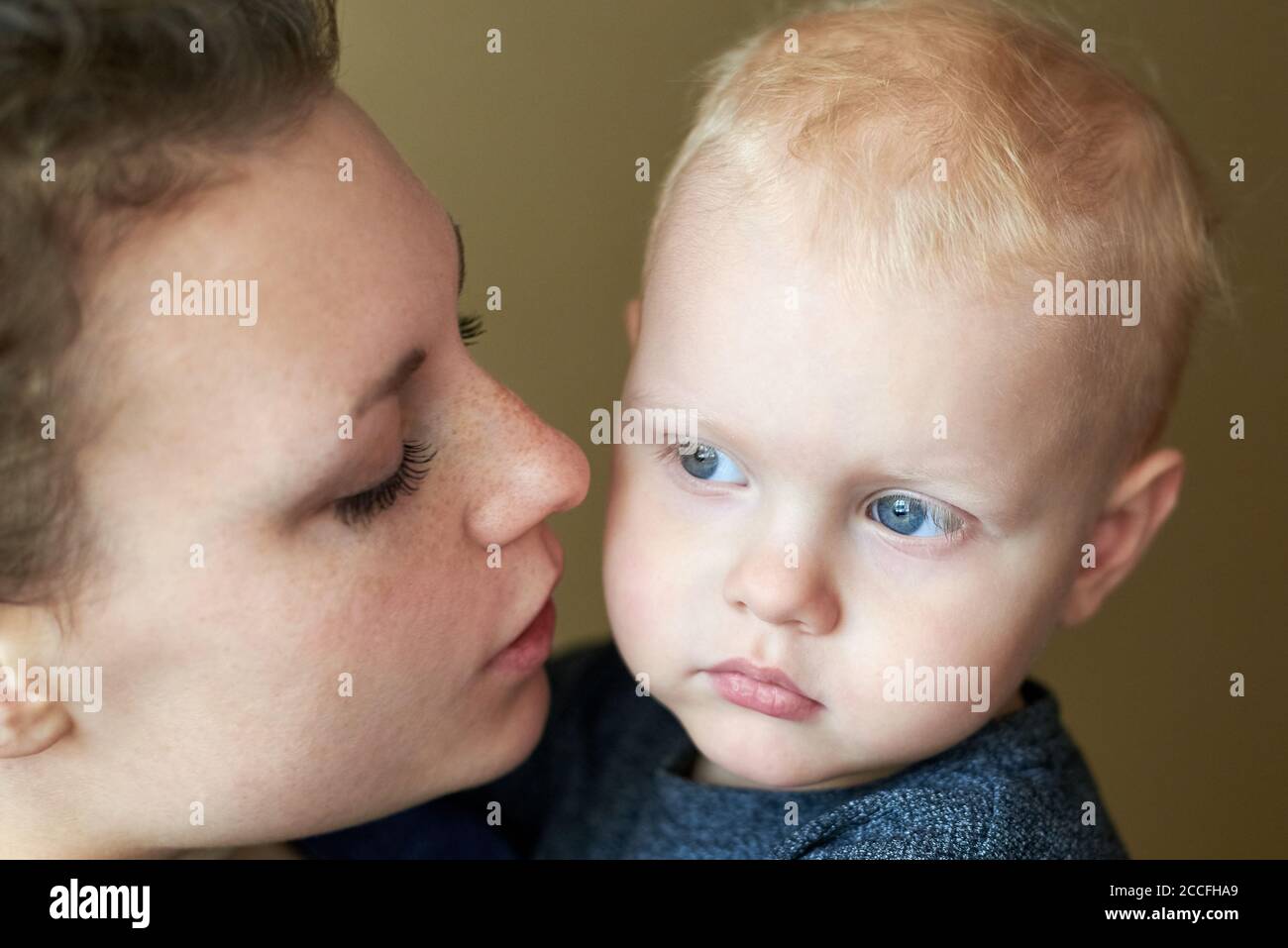 Portrait of a mother speaking with her little son with blue eyes, close-up. Stock Photo