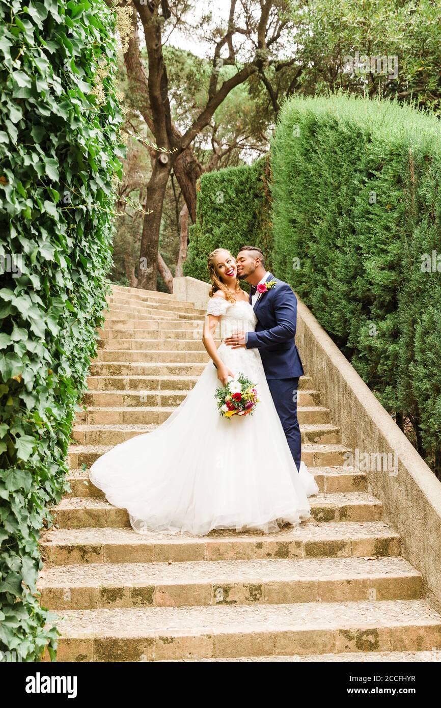 Newlyweds kissing while exiting the church after wedding ceremony, family  and friends celebrating their love with the shower of soap bubbles, custom  Stock Photo - Alamy