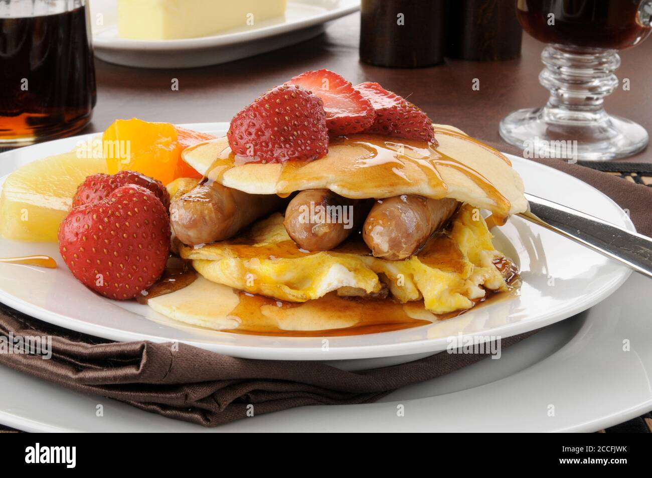 Link sausage and scrambled eggs nested between two pancakes Stock Photo Alamy