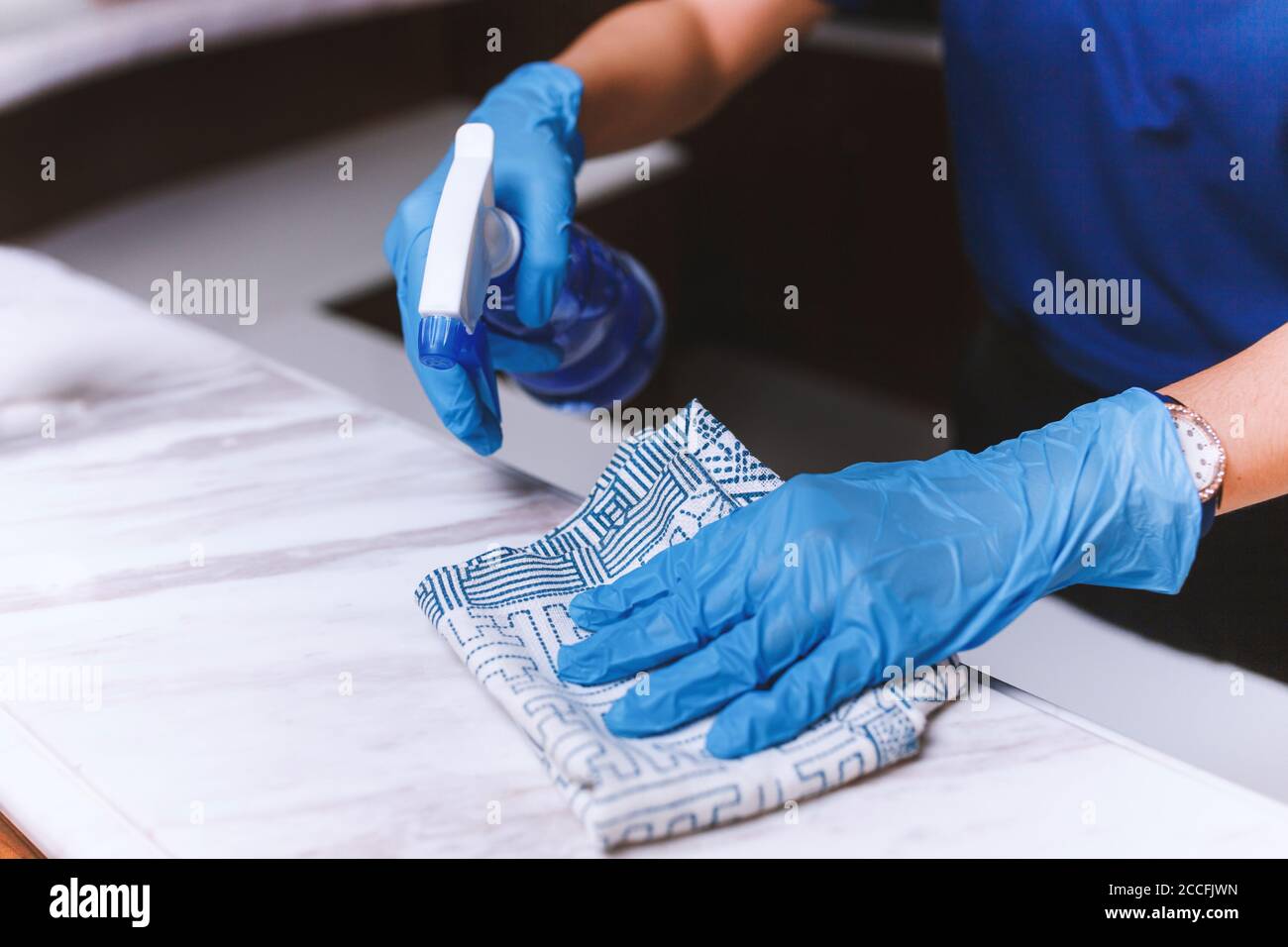 Cleaning home table sanitizing kitchen table surface with disinfectant spray bottle washing