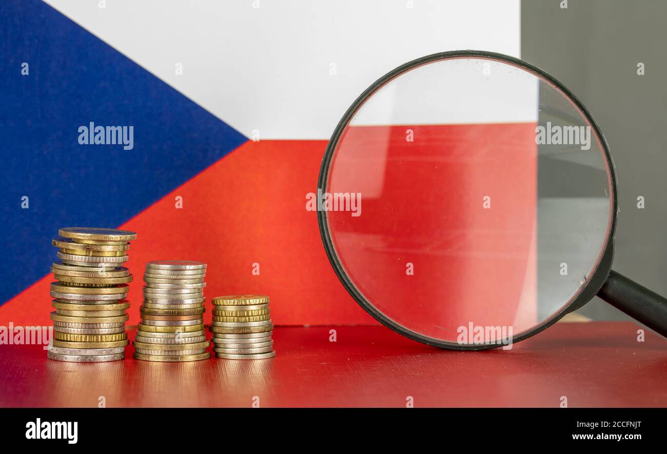 Magnifying glass and coins in front of Czechoslovakia flag, country economy concept Stock Photo
