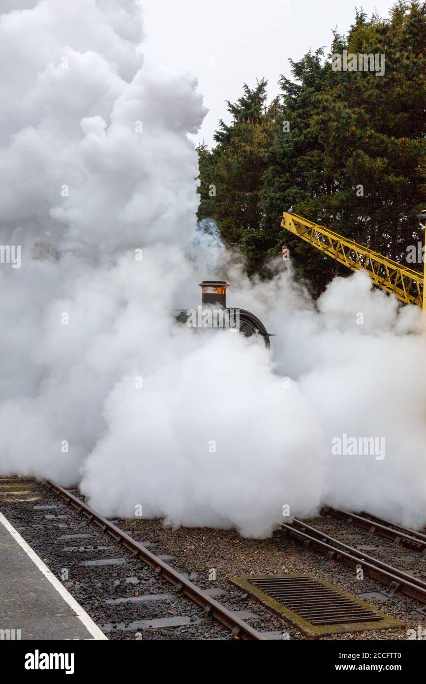 Ex-GWR steam loco 6960 'Raveningham Hall' makes dramatic departure from the engine shed at Minehead, West Somerset Railway Spring Gala, England, UK Stock Photo