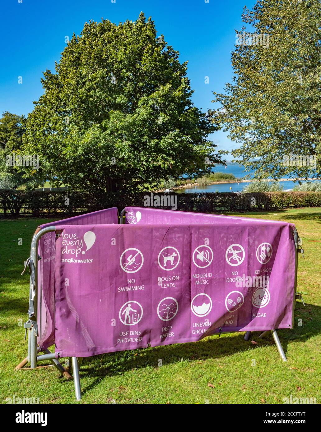 Printed canvas sign draped over metal barriers, with rules and advice to visitors at Rutland Water Park, in the summer sunshine. England, UK. Stock Photo
