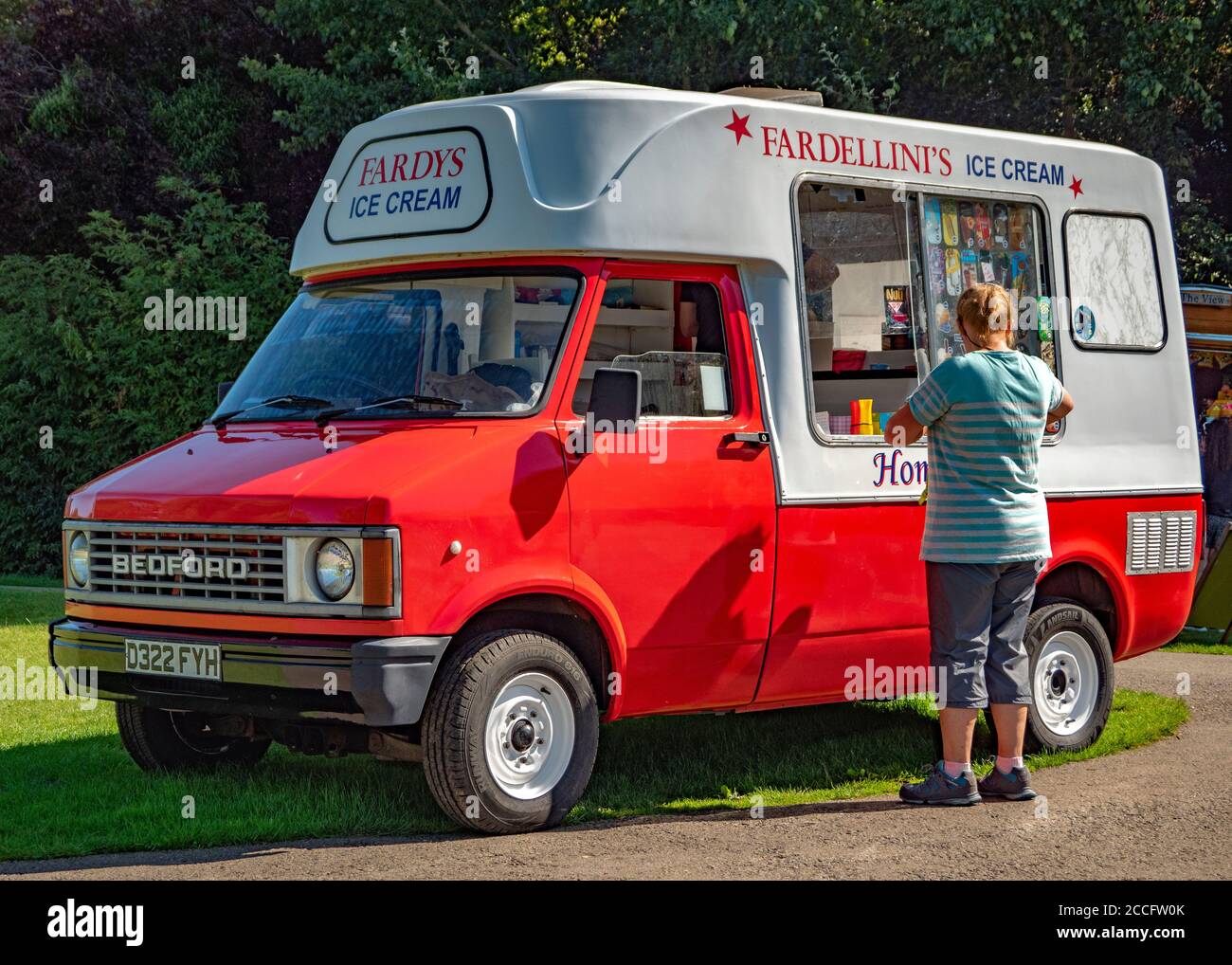 Closeup of a woman buying ice cream from a seller in an old Bedford van, in the summer sunshine, at Rutland Water Park, Normanton, England, UK. Stock Photo