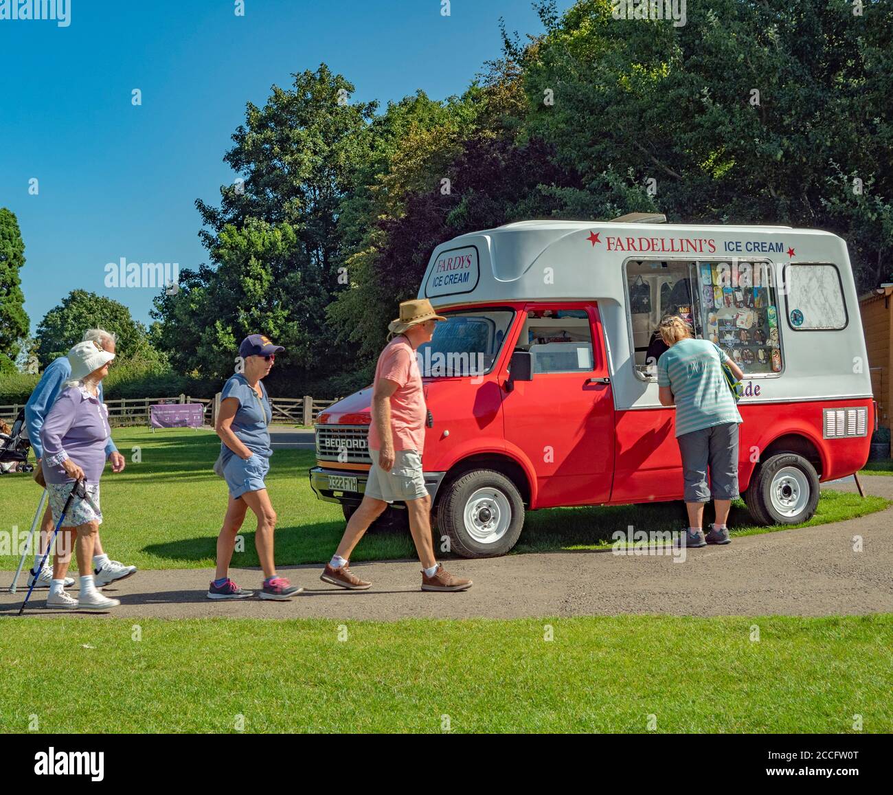 Woman buying ice cream from a seller in an old Bedford van, with