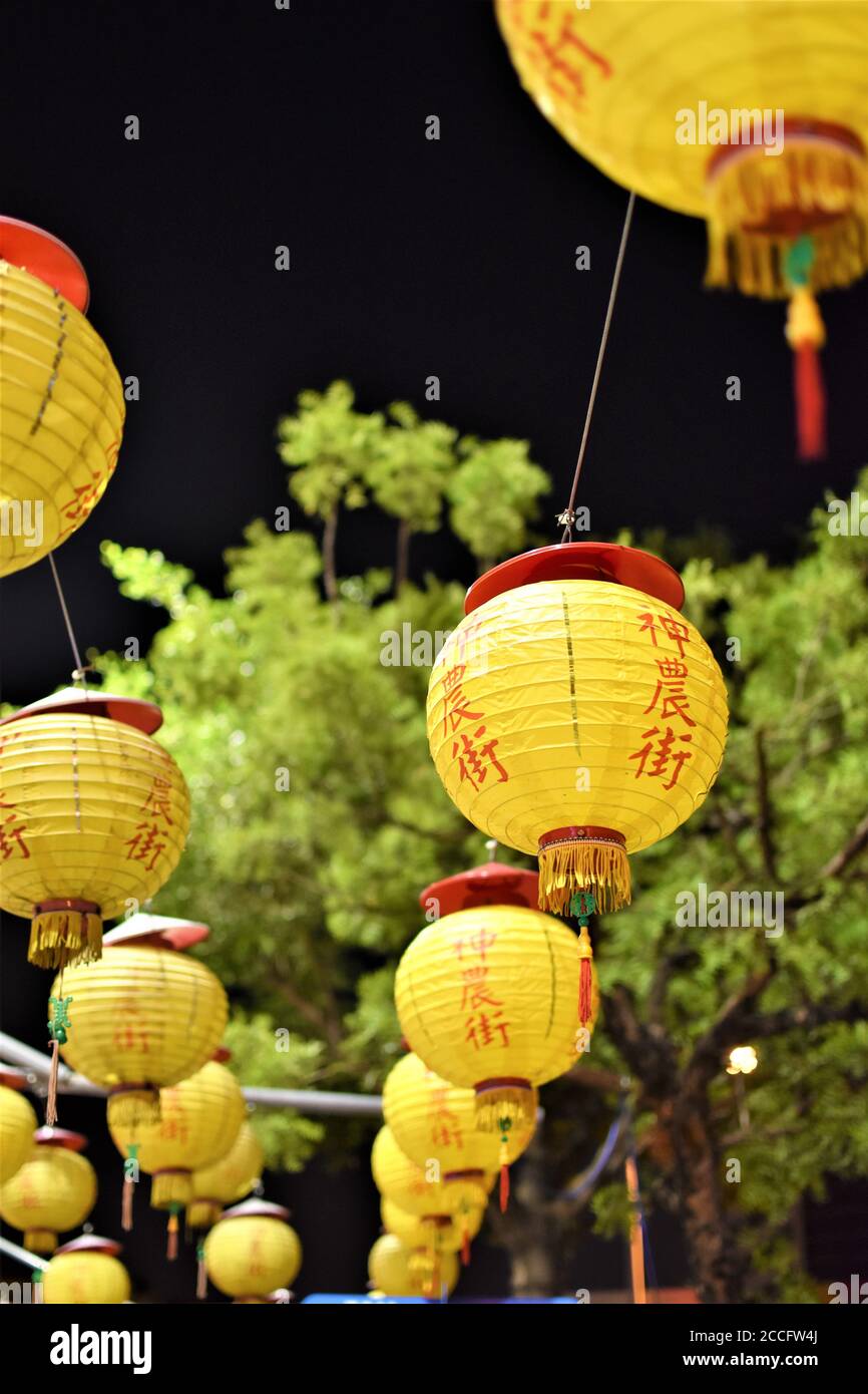 Yellow Chinese lanterns made of paper decorate the sidewalks of a small