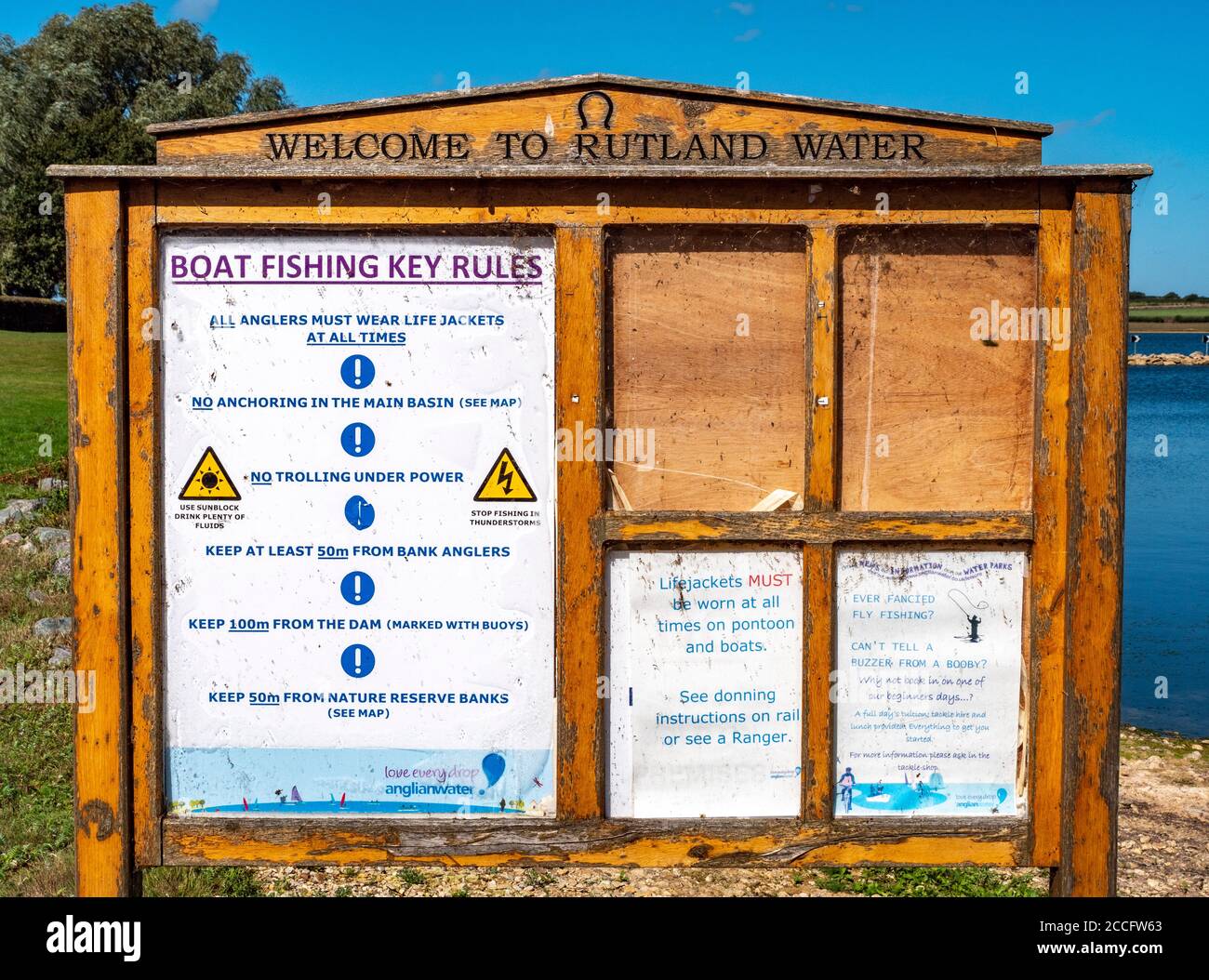 Old wooden visitor notice board with boating and angling rules, next to Rutland Water – a reservoir, artificial lake and nature reserve. England, UK. Stock Photo