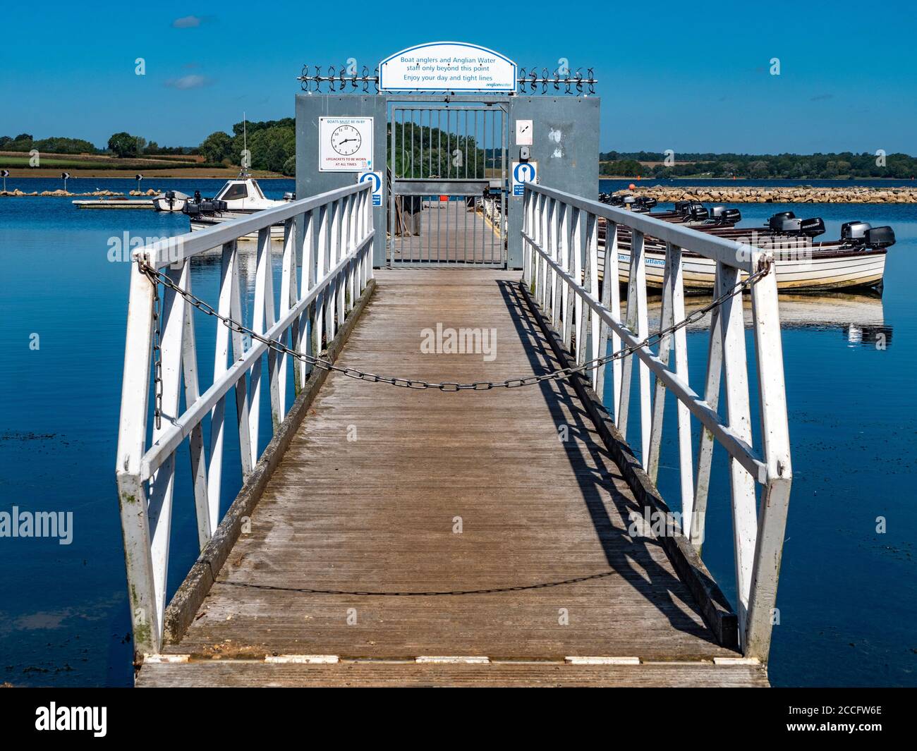 Jetty and gate leading to motor boats for fishing on Rutland Water – a reservoir, artificial lake and nature reserve. Rutland, England, UK. Stock Photo