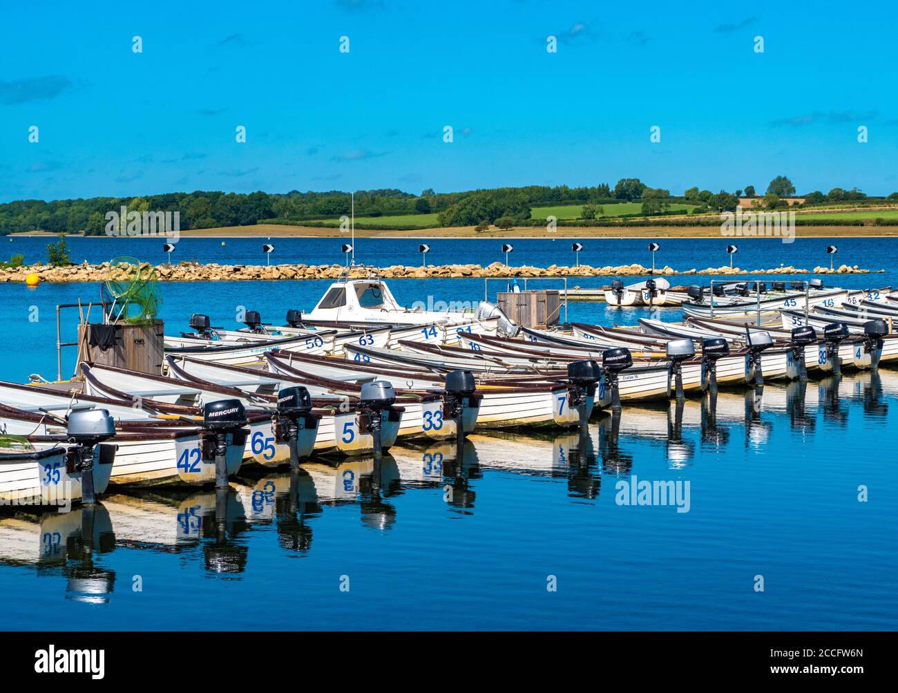 A line of unmanned motor boats for fishing on Rutland Water – a reservoir, artificial lake and nature reserve in Rutland, England, UK. Stock Photo