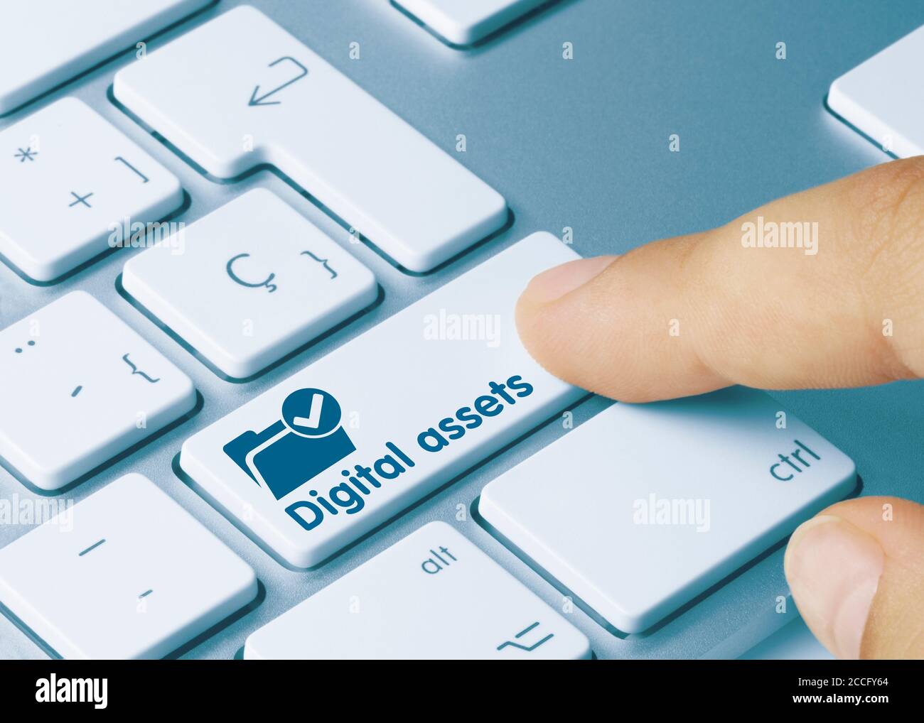 Digital assets Written on Blue Key of Metallic Keyboard. Finger pressing key. Stock Photo
