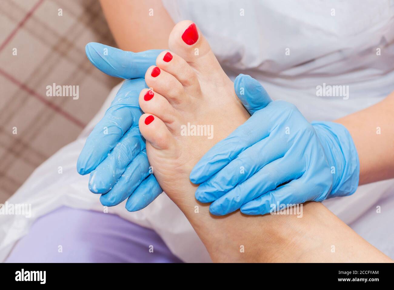 Pedicure moisturizing cram after dead skin remover foot rasp woman in nail salon. Stock Photo