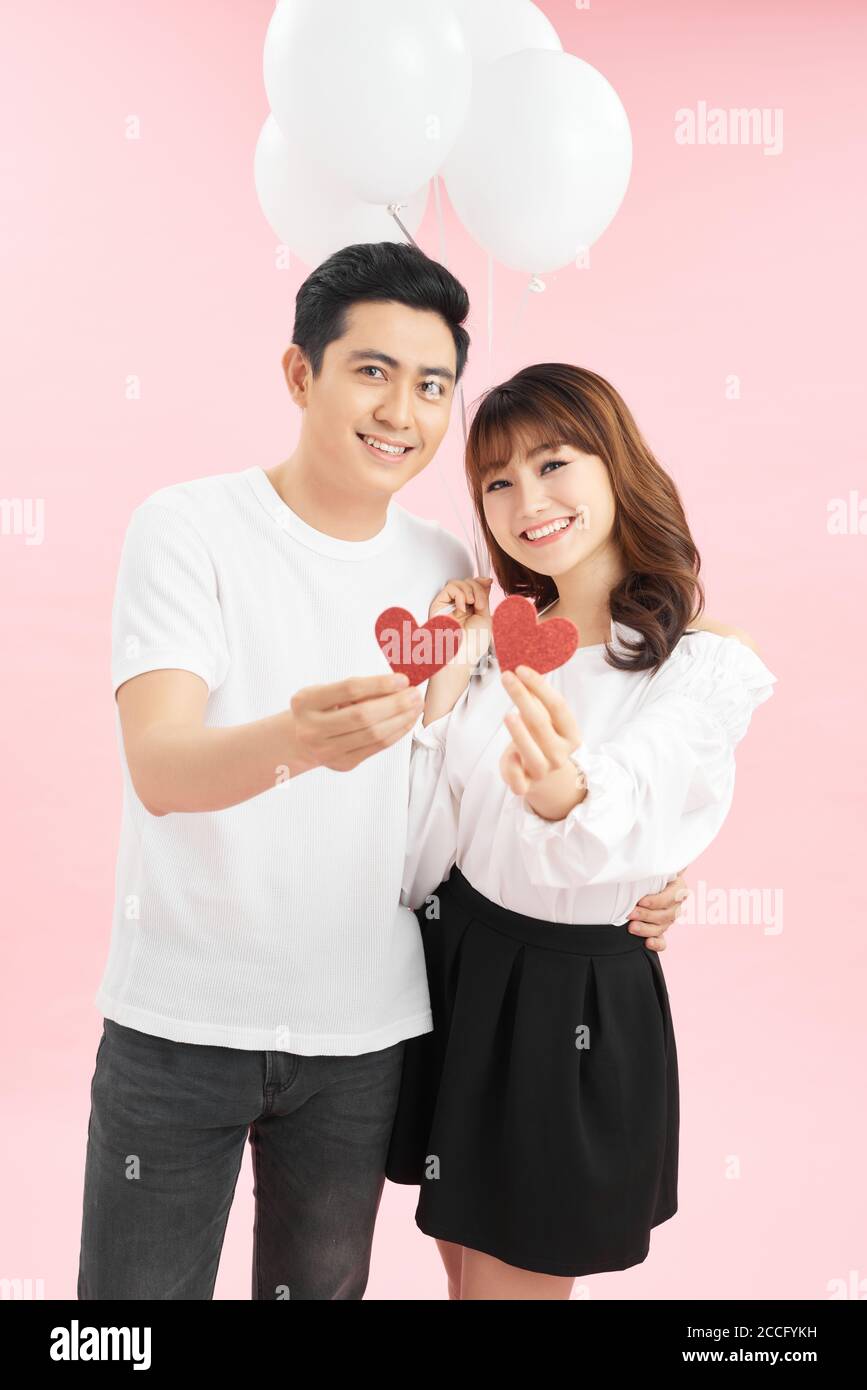 Beautiful couple in love with red balloon holding heart shape for ...