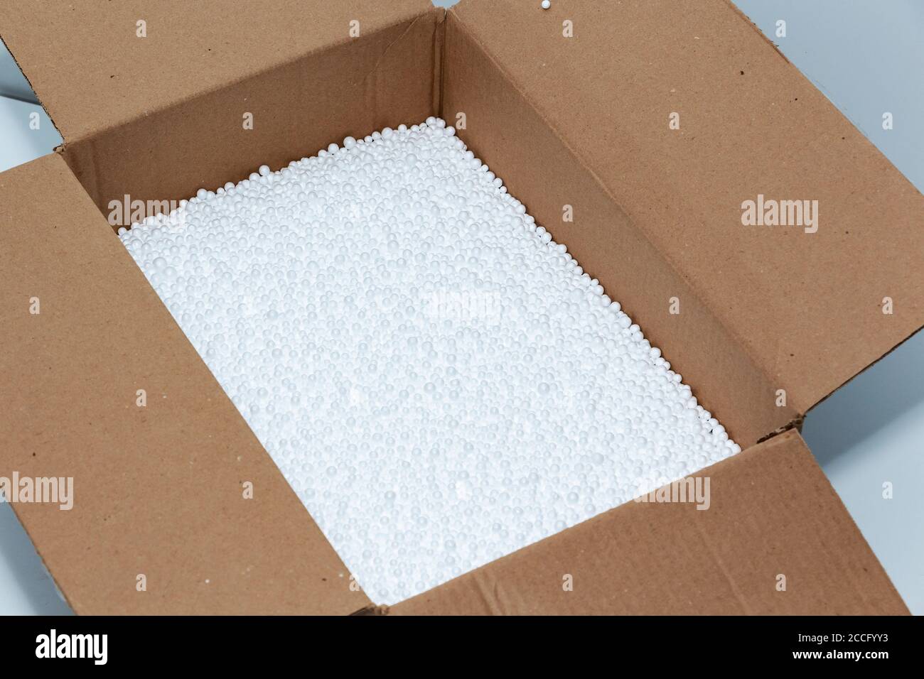 Round foam balls in a cardboard box. Environmental protection. Stock Photo