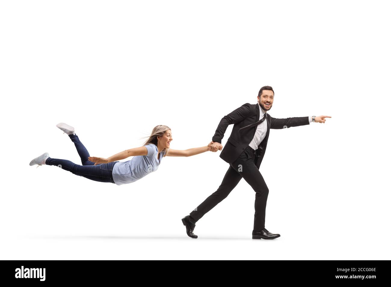Full length profile shot of a man in a suit running and pulling a woman by the hand isolated on white background Stock Photo