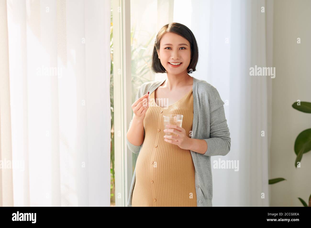 Young pregnant woman taking capsule Stock Photo Alamy