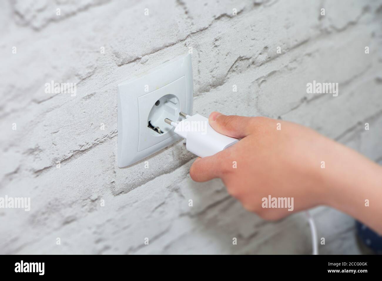 connect the charger to a wall outlet. Save energy-unplug the charger. Stock Photo